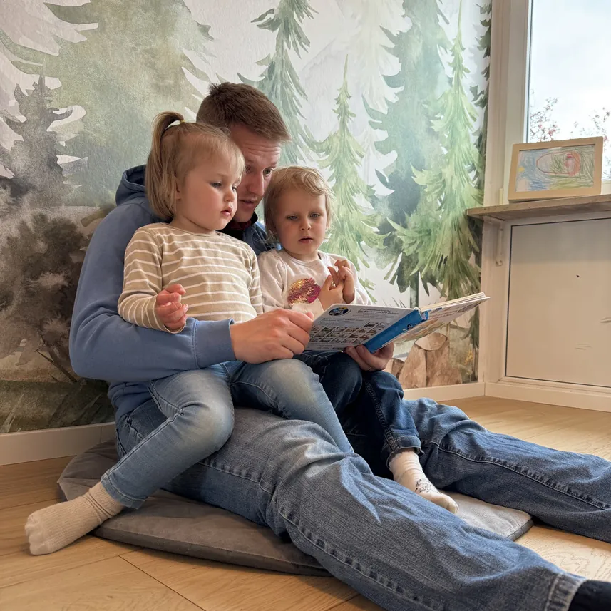 Kind spielt vor einer Wald-Tapete im Kinderzimmer